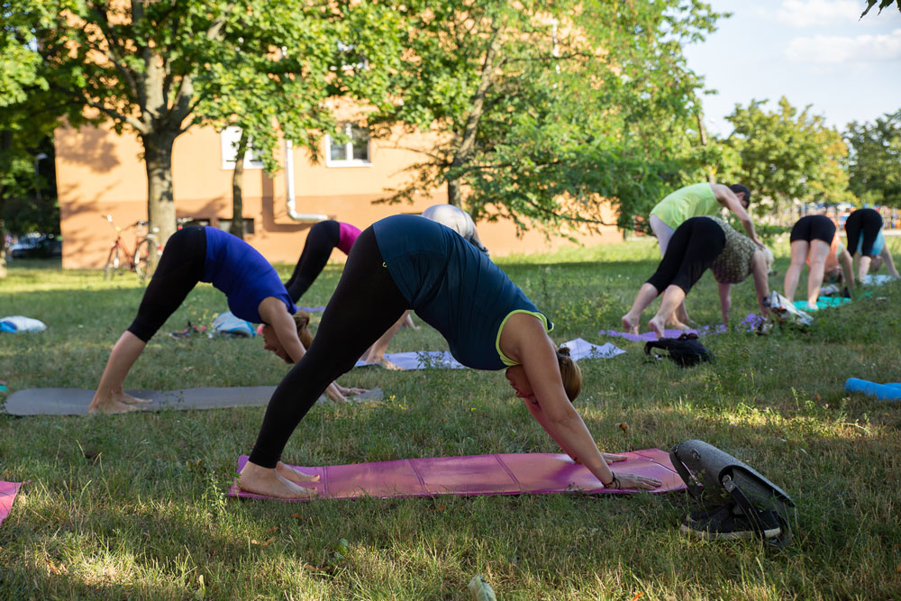 Vitálka - Pilates v meste - ženy cvičiace v prírode na zelenej lúke.