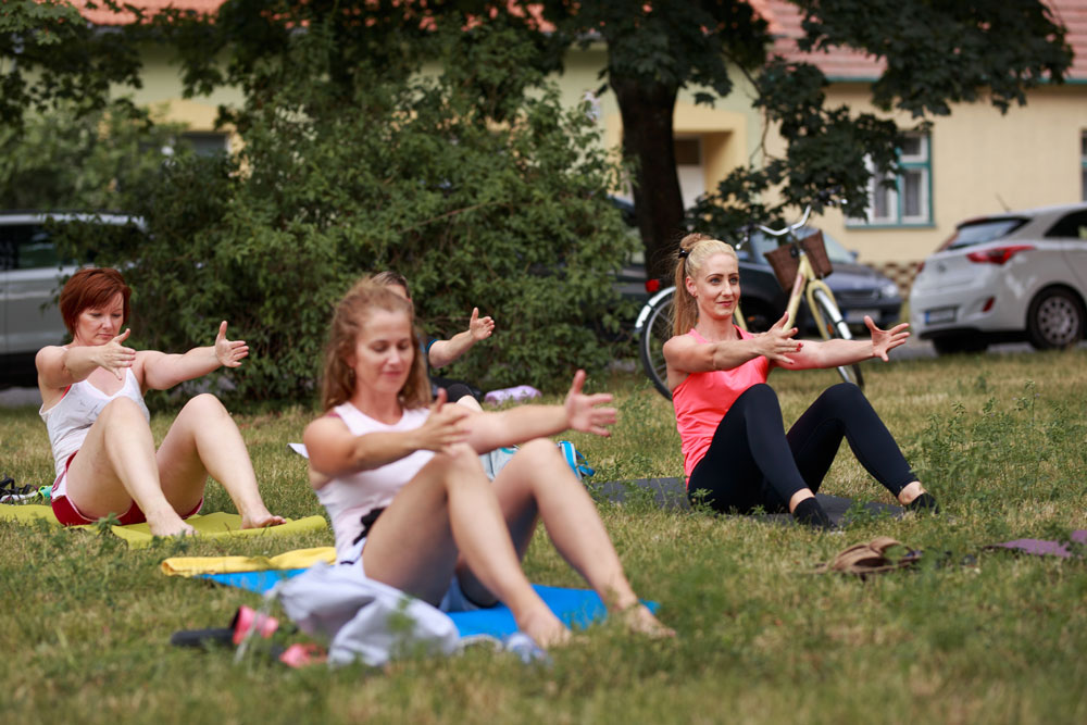 Vitálka - Pilates v meste - ľudia cvičiaci pilates na trávnatej ploche.
